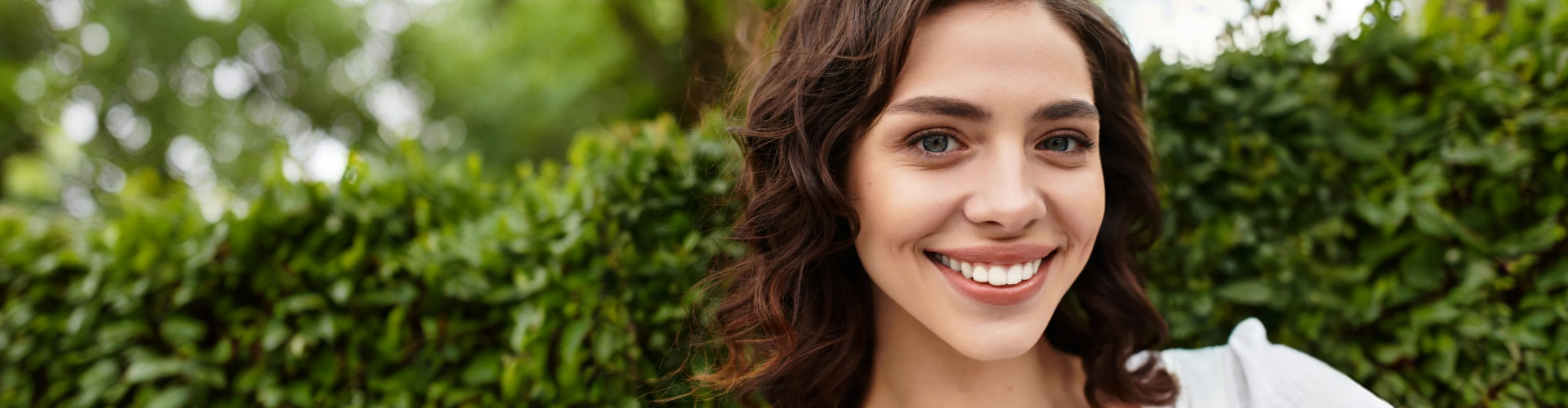 Smiling woman in front of plants.